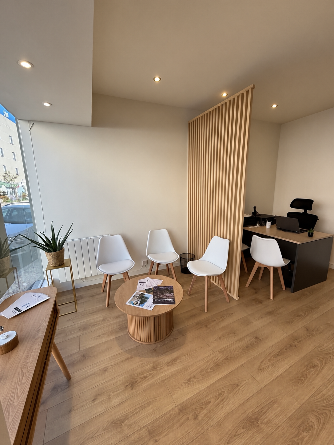 Espace d’accueil du centre de Grigny, avec sièges et bureau séparé par des lattes de bois